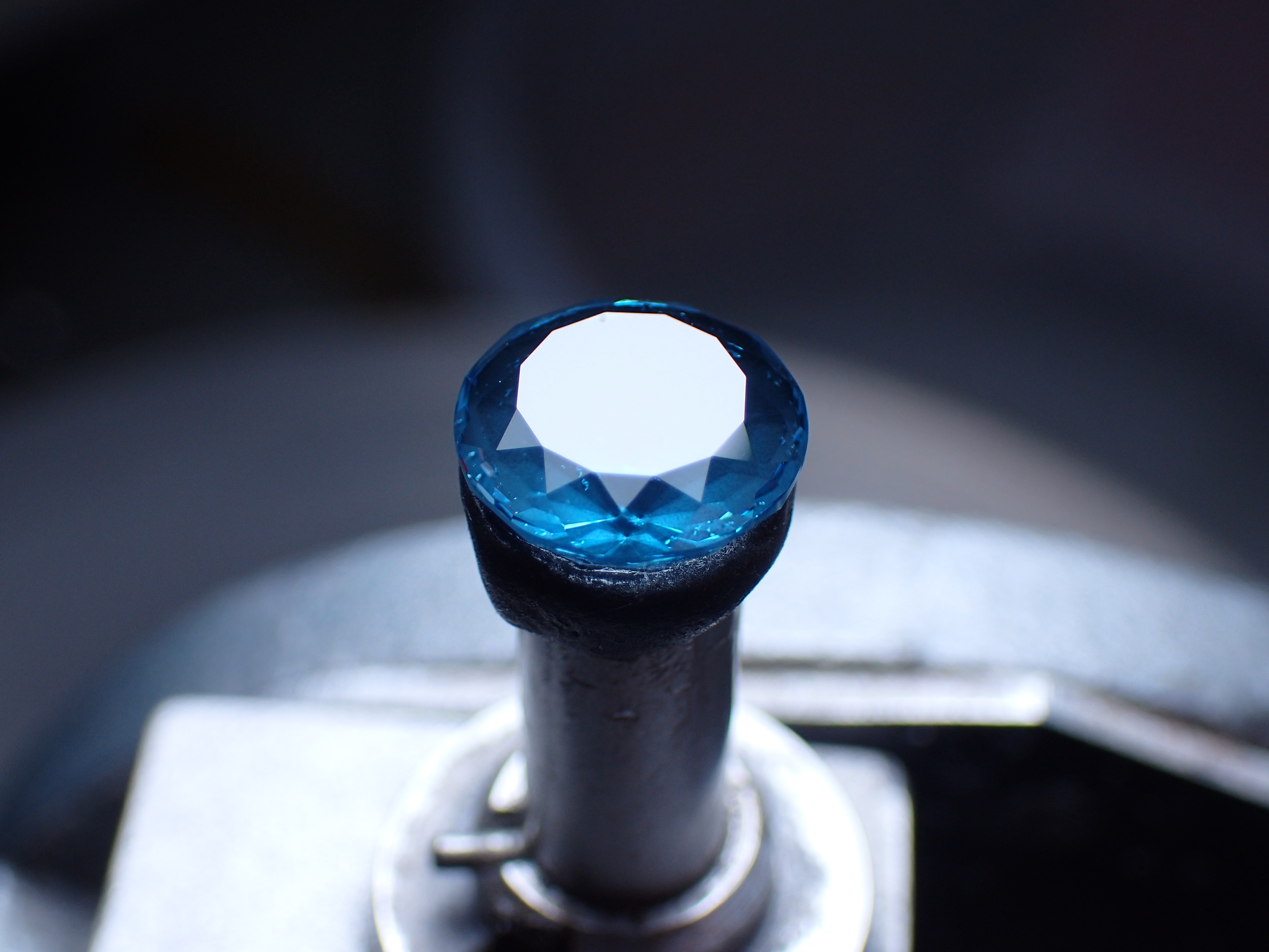 A faceted gemstone mounted on a dop, ready for cutting