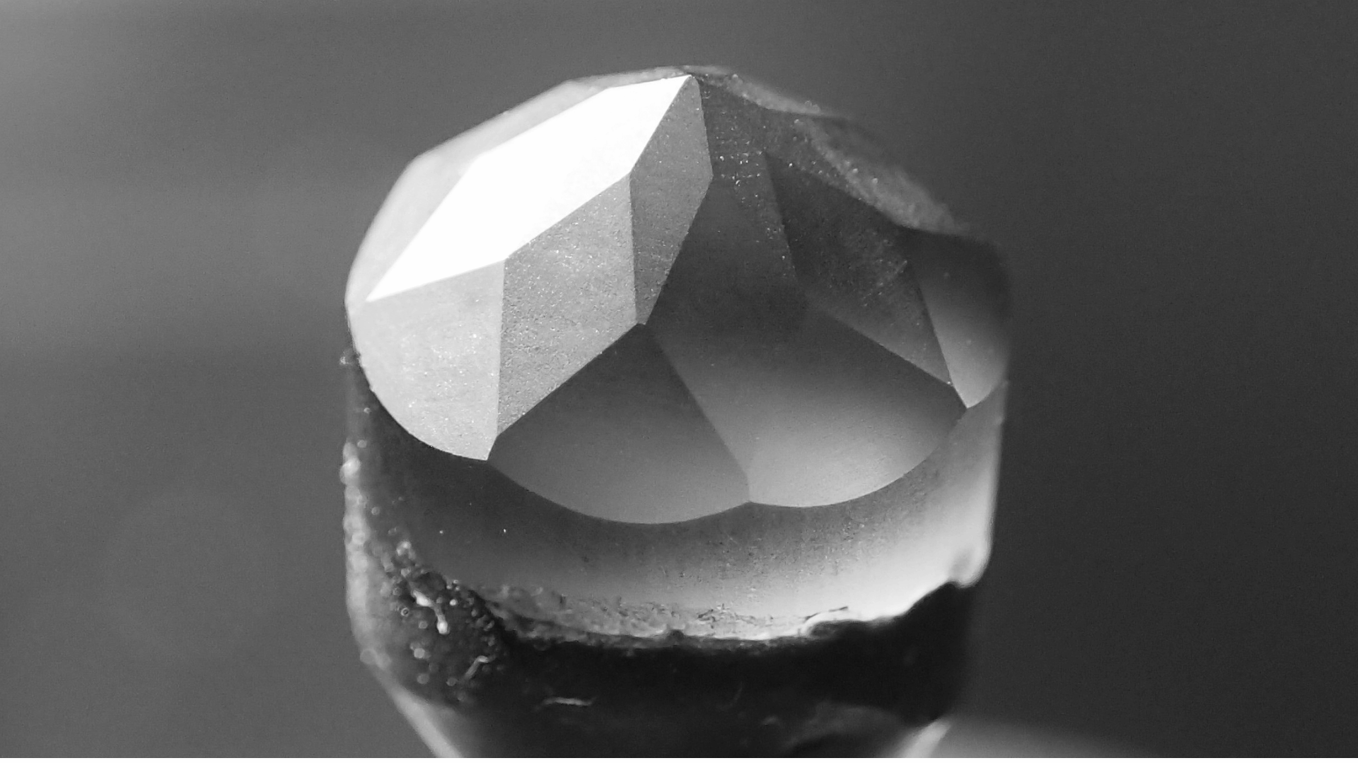 Landing Macro view of a faceted stone mounted on a dop
